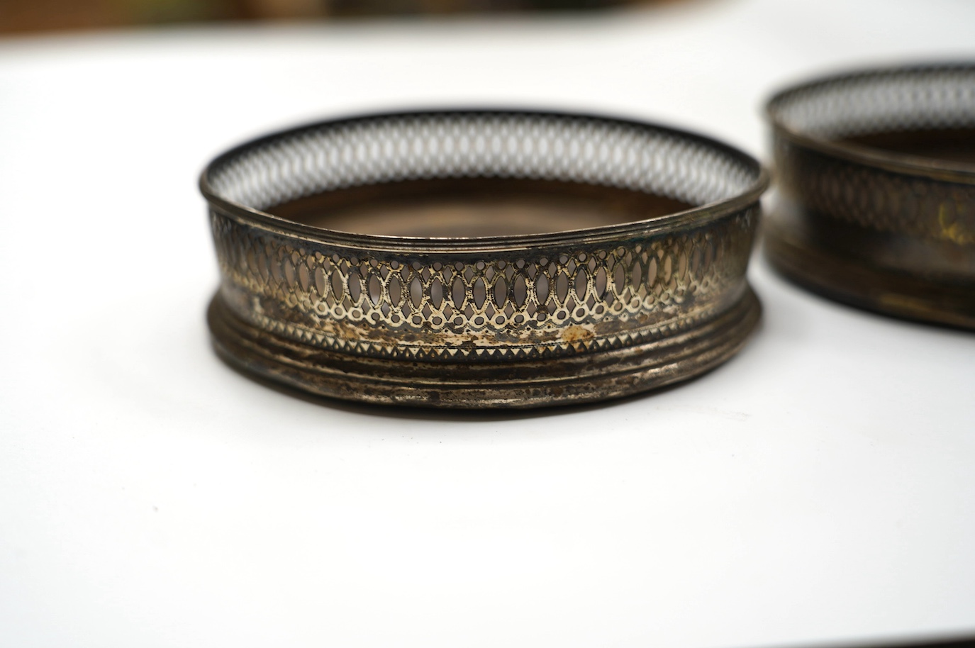 A pair of George III silver mounted wine coasters, diameter 12.1cm, marks rubbed, possibly Robert Hennell, London, 1792. Condition - poor